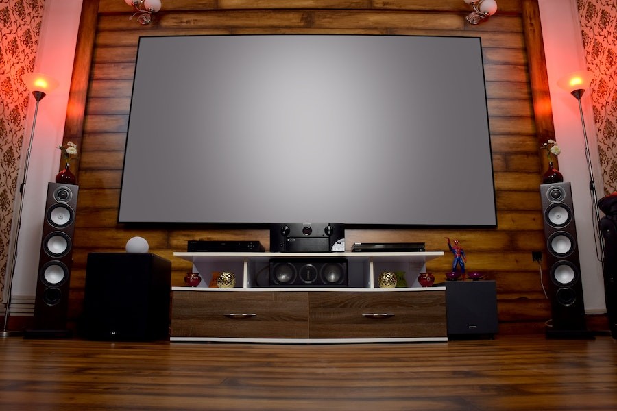 A home theater room with speakers, a projection screen, and equipment. 