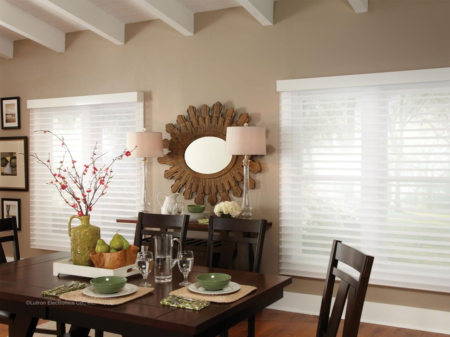 a dining room with brown tables and chairs and white blinds on the windows