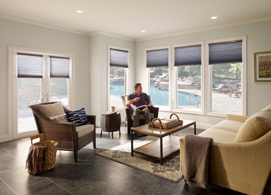 a man sitting in a living room with glass windows