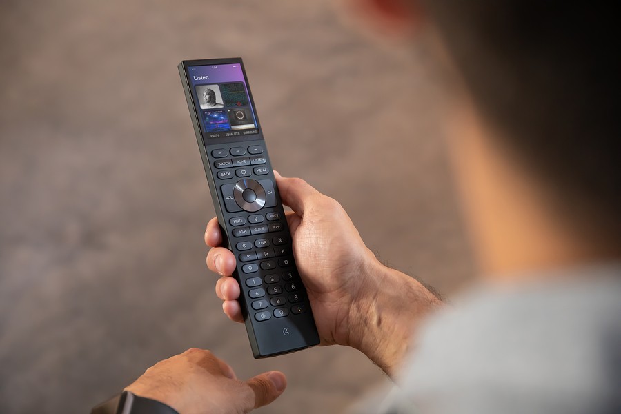 A hand holding a Control4 Halo remote. 