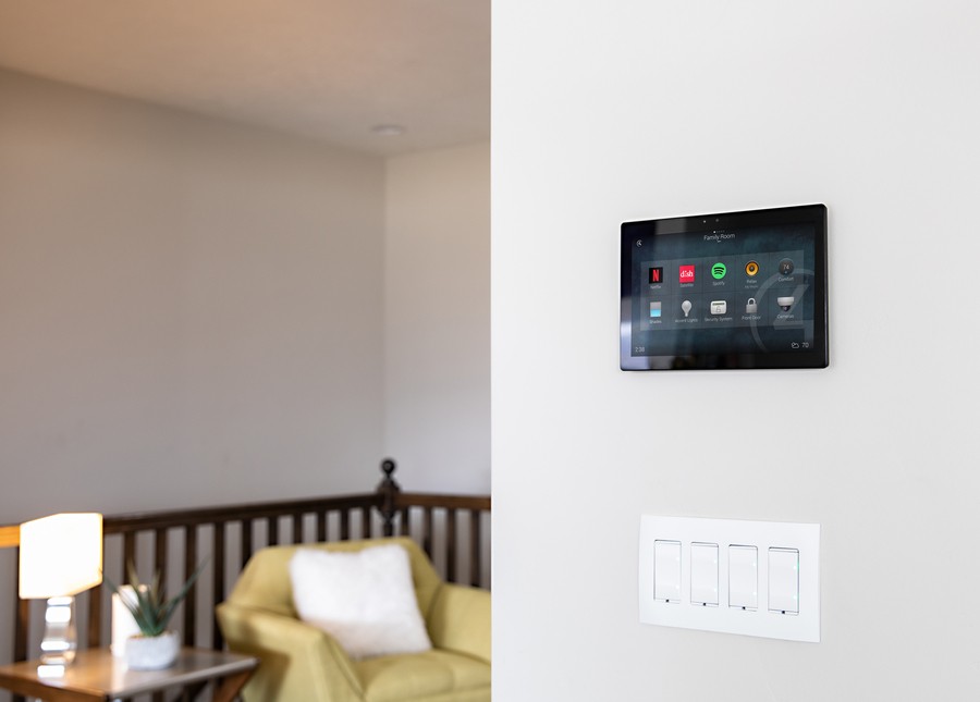 a Control4 panel mounted on the wall of a living room