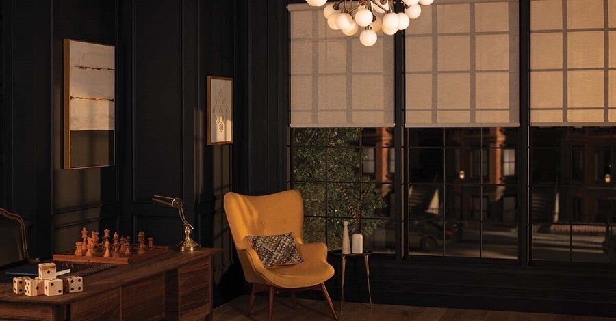 a living room with a yellow chair sitting near the windows 