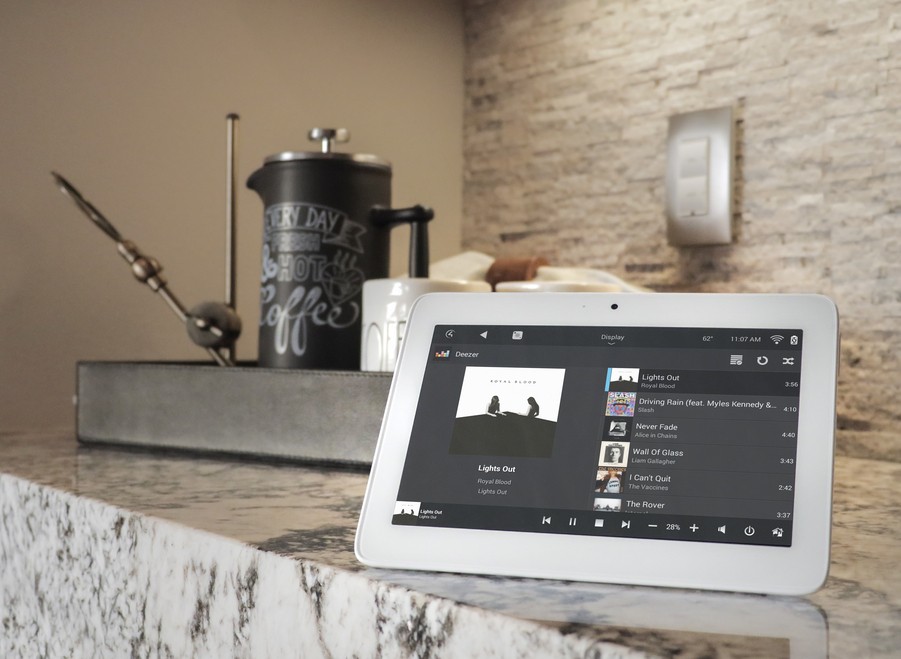 a touchscreen device sitting on a console showing a music playlist 